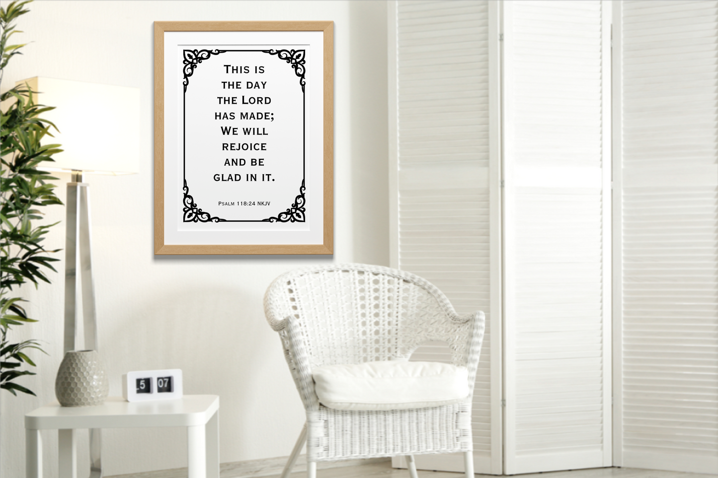Psalm 118:24 NKJV printable wall art Christian bible verse typography displayed in a wooden frame on a neutral wall, in a modern room with a white wicker chair and white room divider.