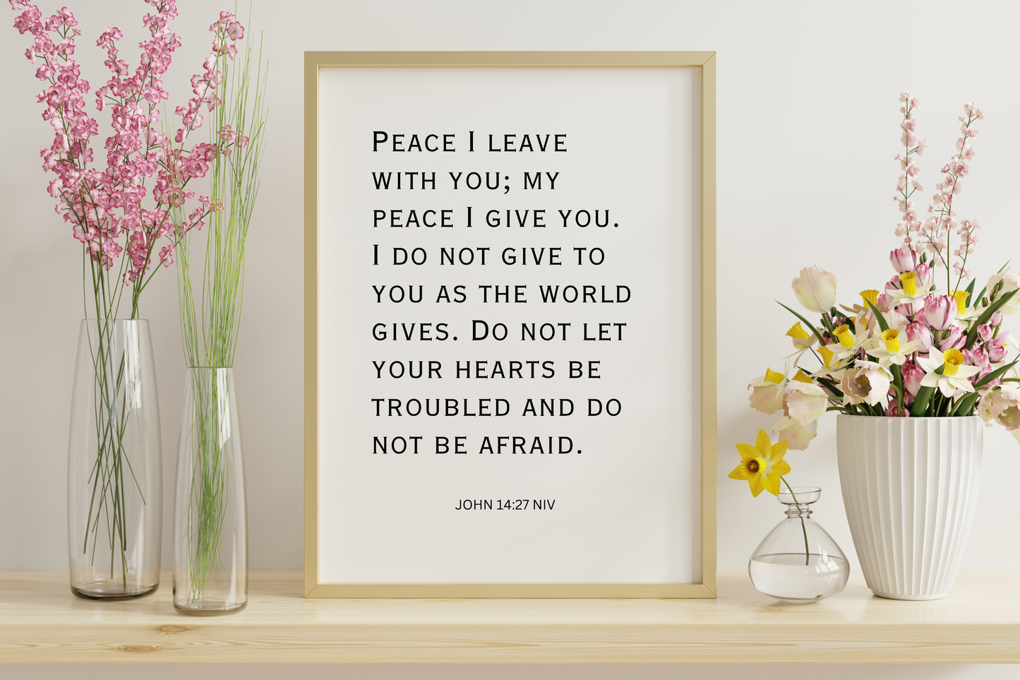 Printable typography wall art featuring John 14:27 framed in a simplistic hallway setting with white walls and minimalist floral decor.