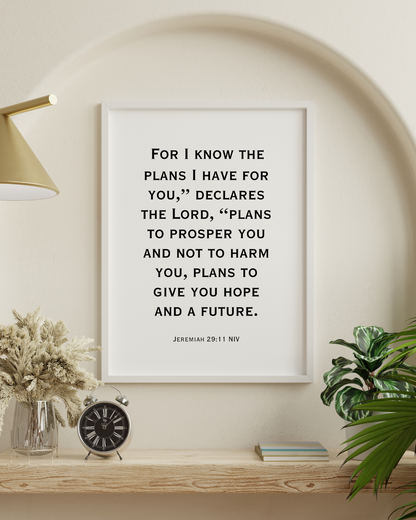 Jeremiah 29:11 NIV printable wall art with Christian bible verse typography displayed in a modern white frame on a neutral wall with decorative plants.