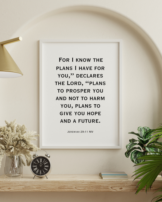 Jeremiah 29:11 NIV printable wall art with Christian bible verse typography displayed in a modern white frame on a neutral wall with decorative plants.