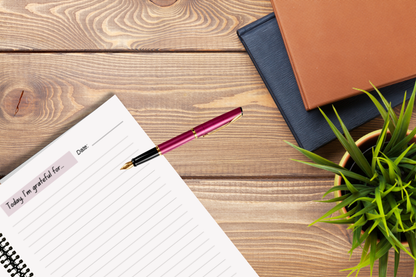 A4 coiled Christian gratitude journal with red pen on desk — faith-based self-care tool for journaling and prayer.