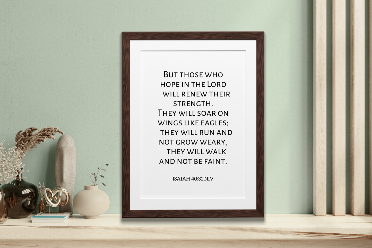 Framed poster with inspirational Christian scripture digital art print of Isaiah 40:31 styled against a wall with decorative items.
