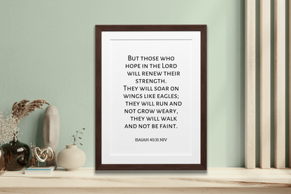 Framed poster with inspirational Christian scripture digital art print of Isaiah 40:31 styled against a wall with decorative items.