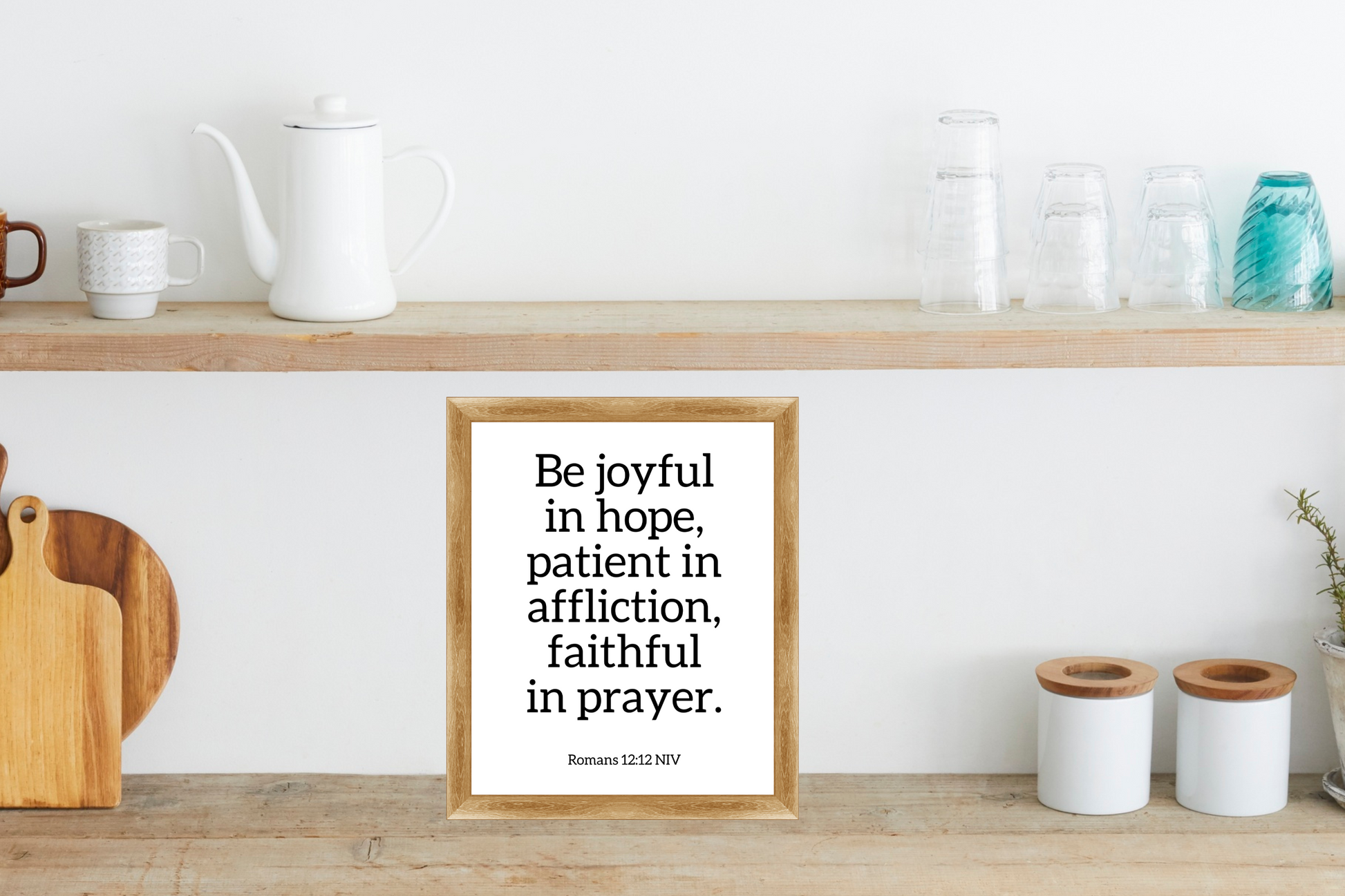 Romans 12:12 printable wall art with Christian bible verse typography displayed in a wooden frame on a kitchen shelf.