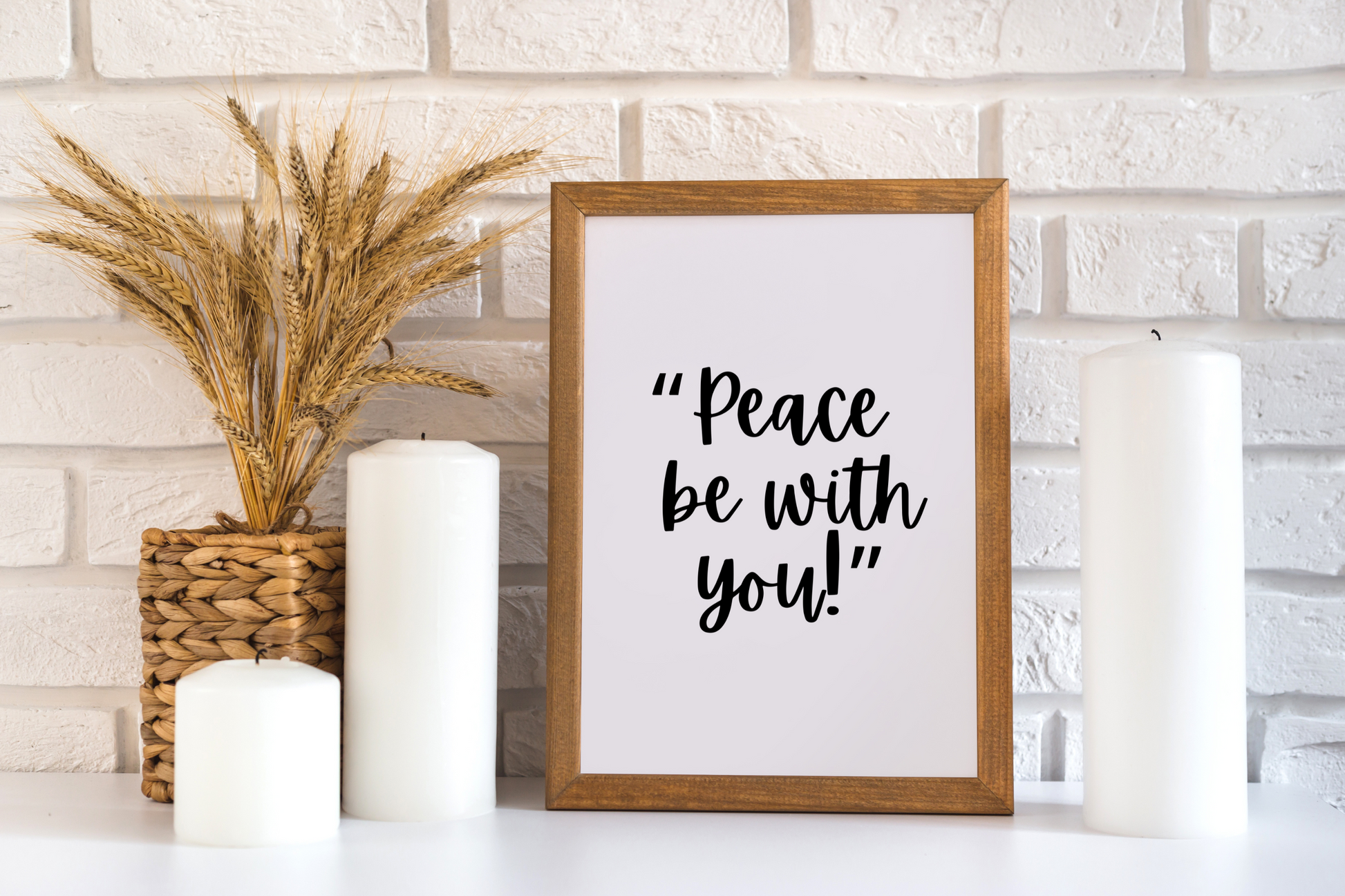 High-definition scripture-inspired printable wall art of Peace Be With You framed sign on a white surface with candles and wheat plant.