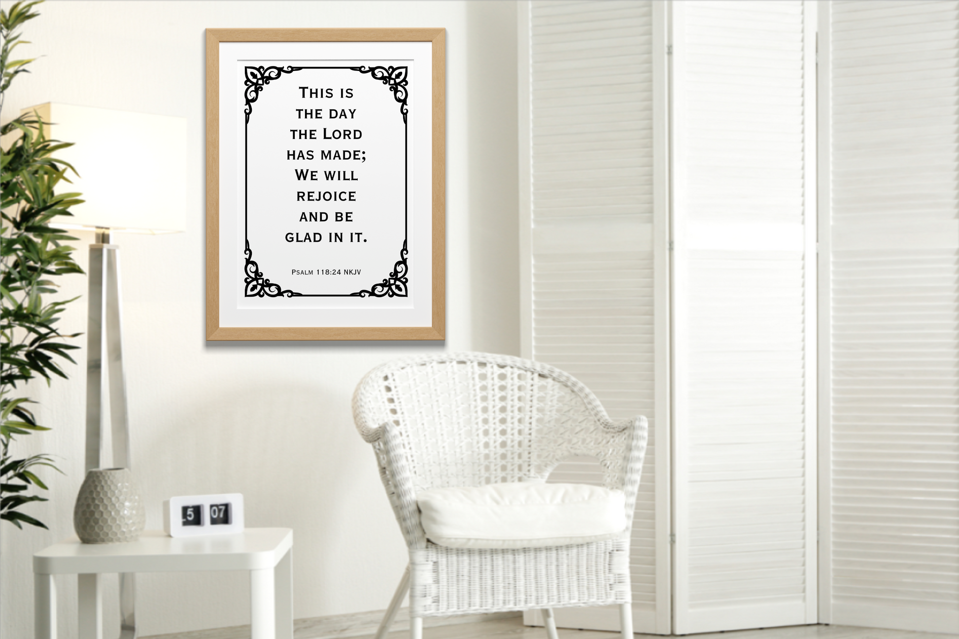 Psalm 118:24 NKJV printable wall art Christian bible verse typography displayed in a wooden frame on a neutral wall, in a modern room with a white wicker chair and white room divider.